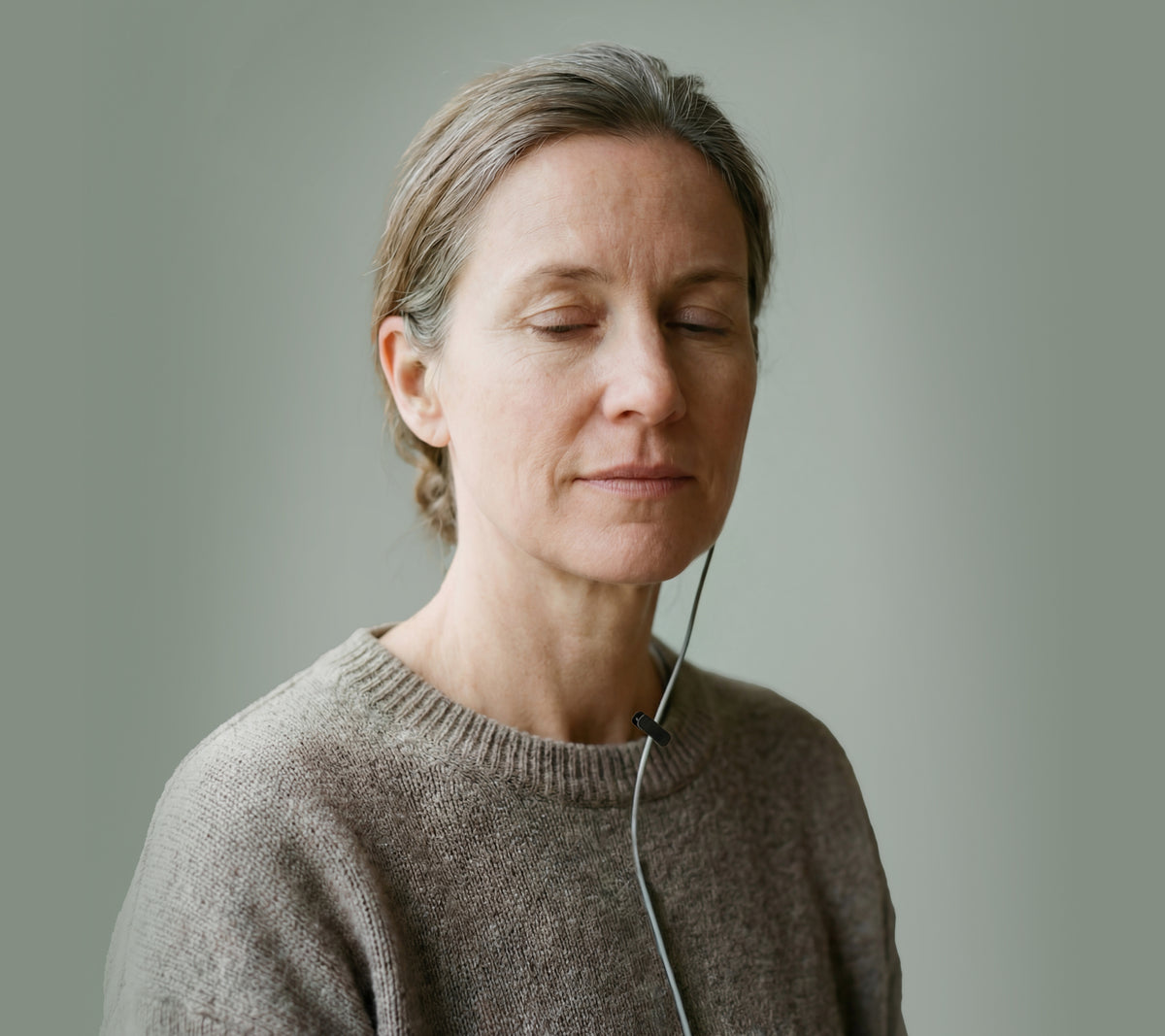 Woman using ZenoWell earpiece for vagus nerve stimulation, promoting relaxation and stress relief through transcutaneous auricular vagus nerve stimulation (taVNS).