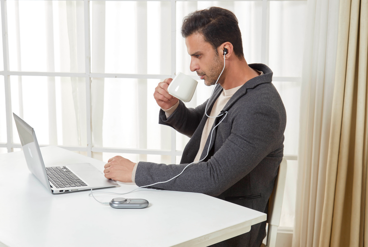 Professional using the ZenoWell Luna device while working, balancing productivity and calm