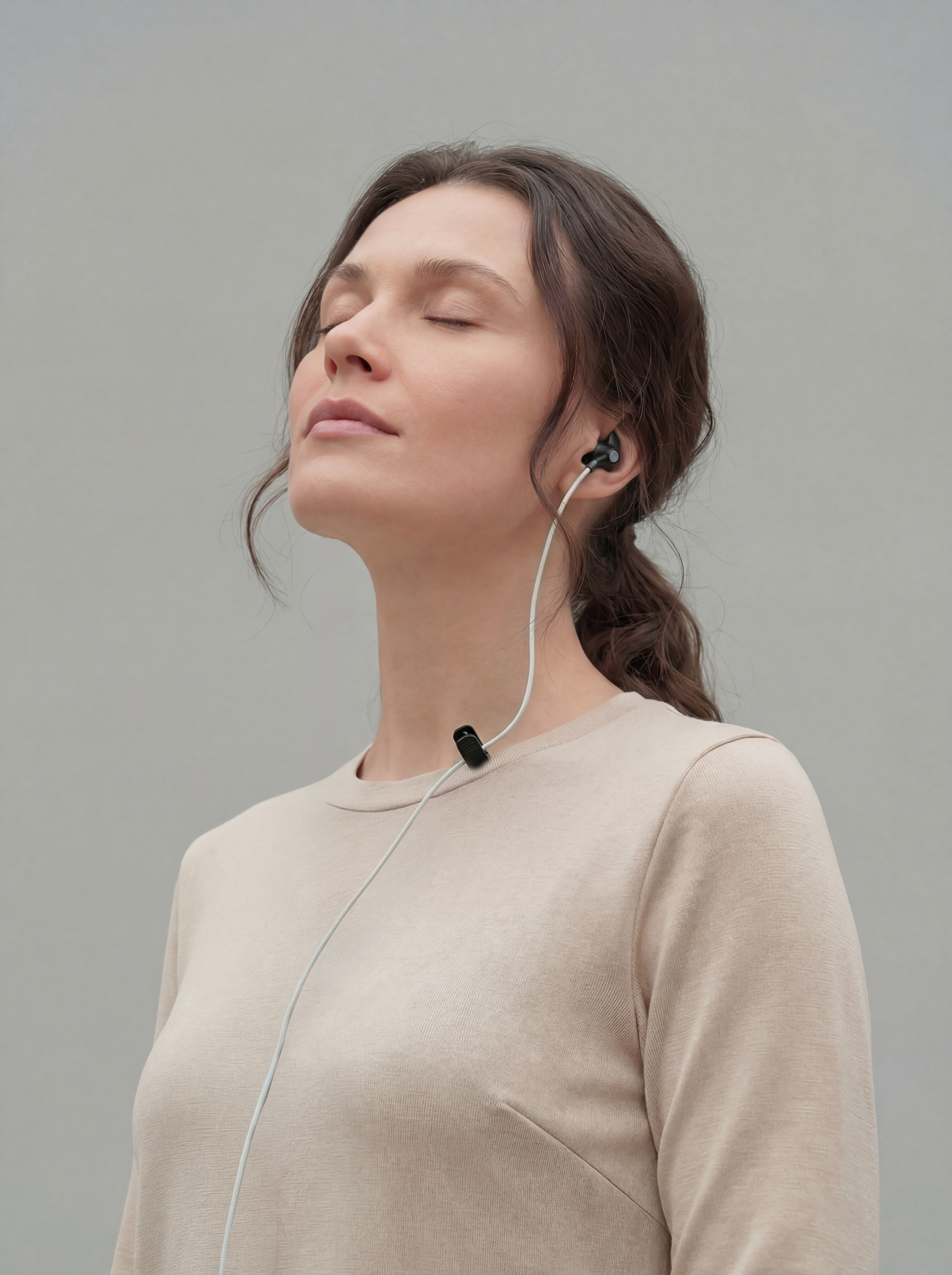 Woman using ZenoWell ear device for stress relief and relaxation, benefiting from vagus nerve stimulation (taVNS) to enhance calm and promote well-being.